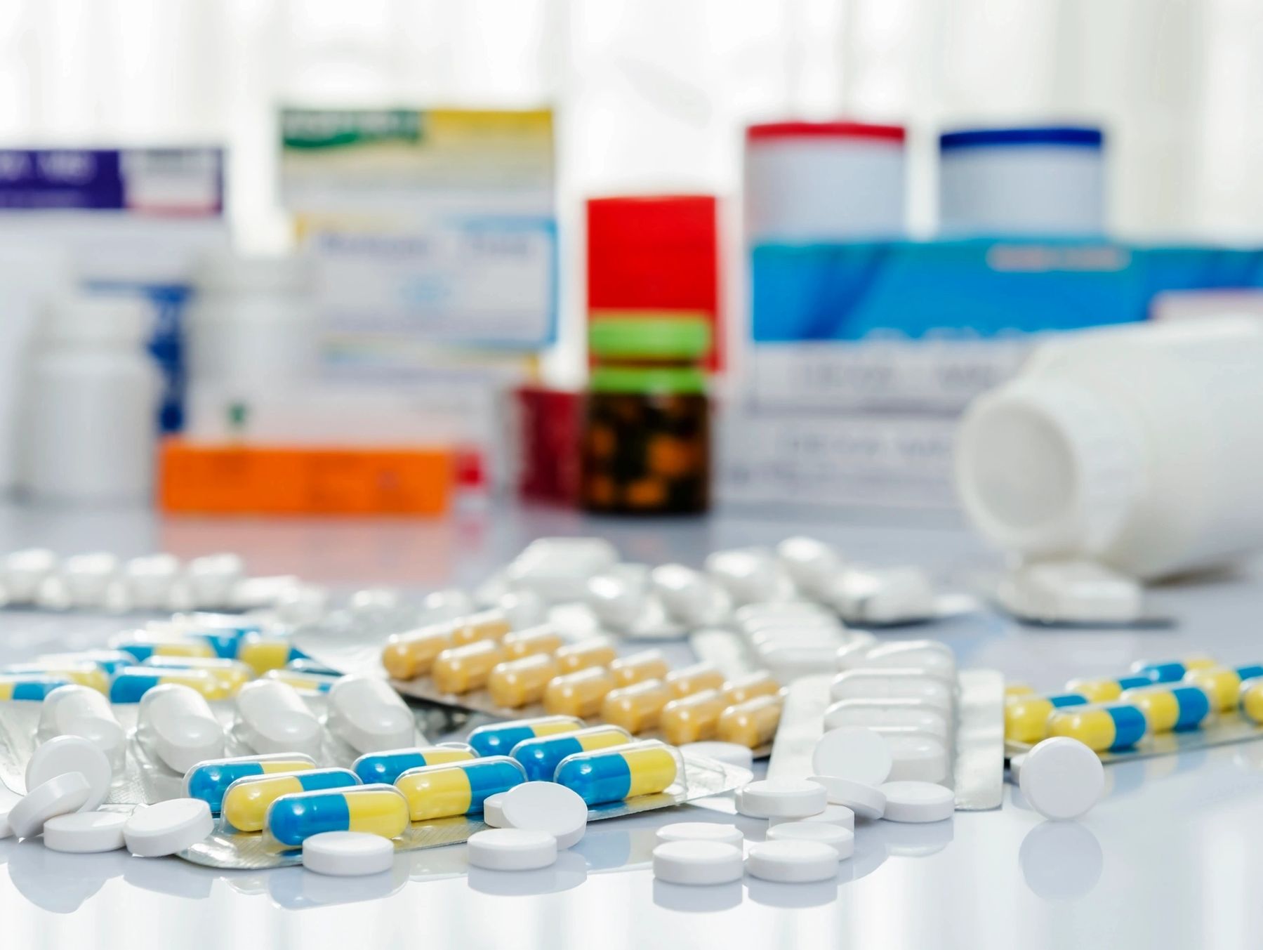 Various pills and capsules arranged on a white surface